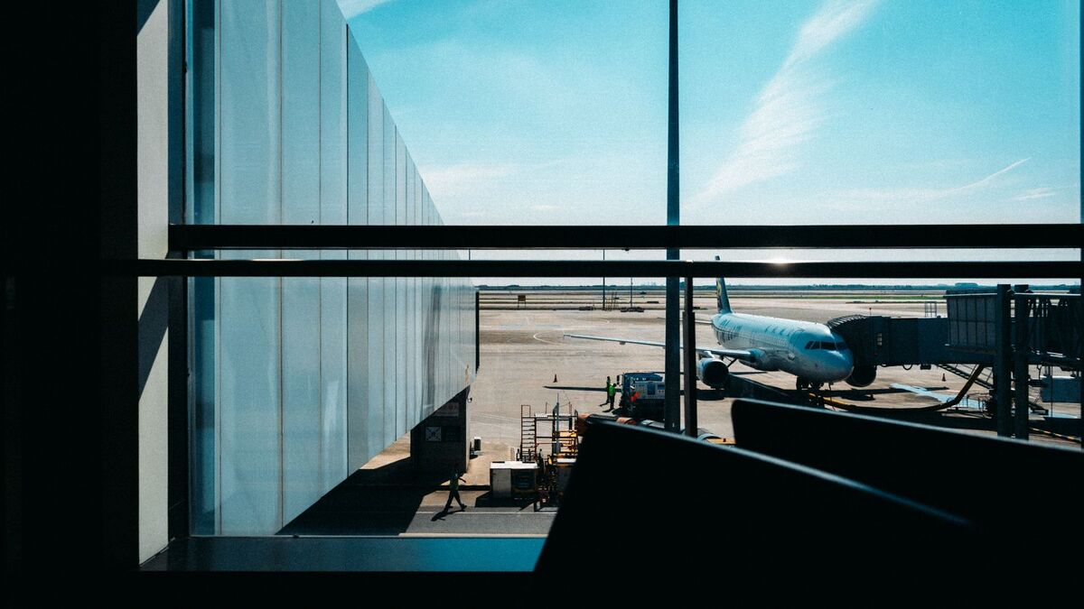 Airliner parked at the gate, seen through a terminal window