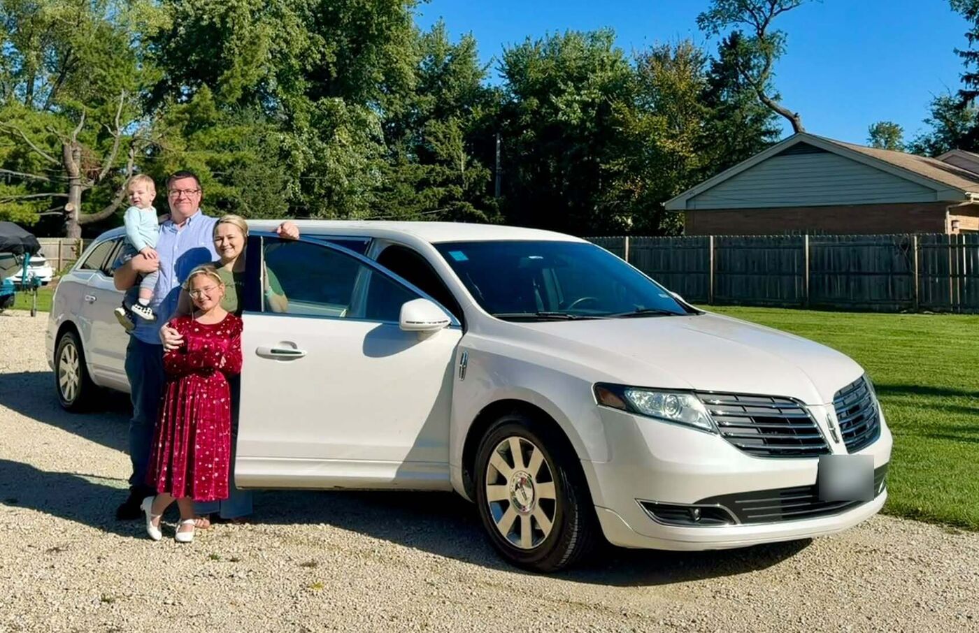 The family behind J Class Limousine standing beside their white limousine
