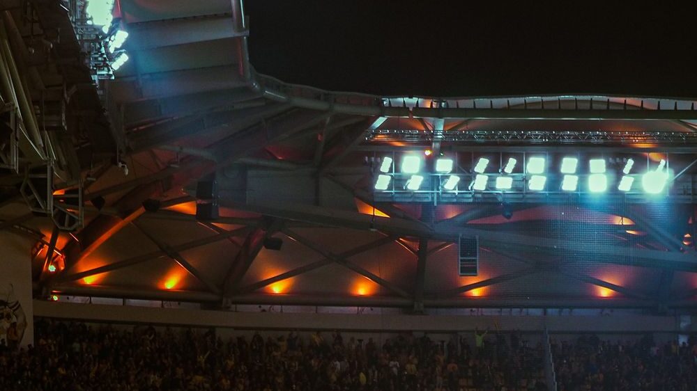 Packed stadium under the lights at a night game