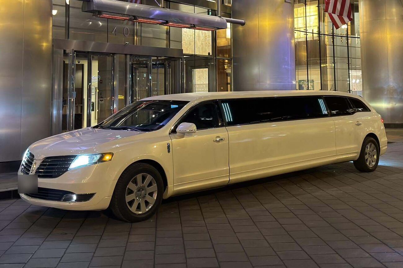 White stretch limousine outside a downtown Chicago hotel at night